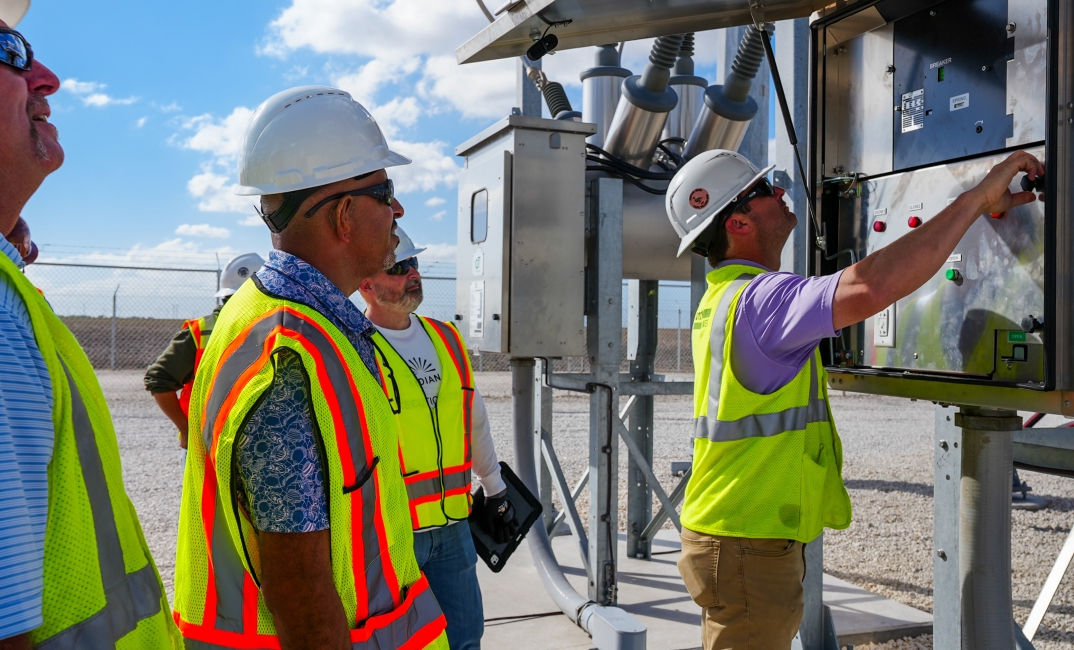 Lydian team members inspecting electrical equipment at an energy project site.