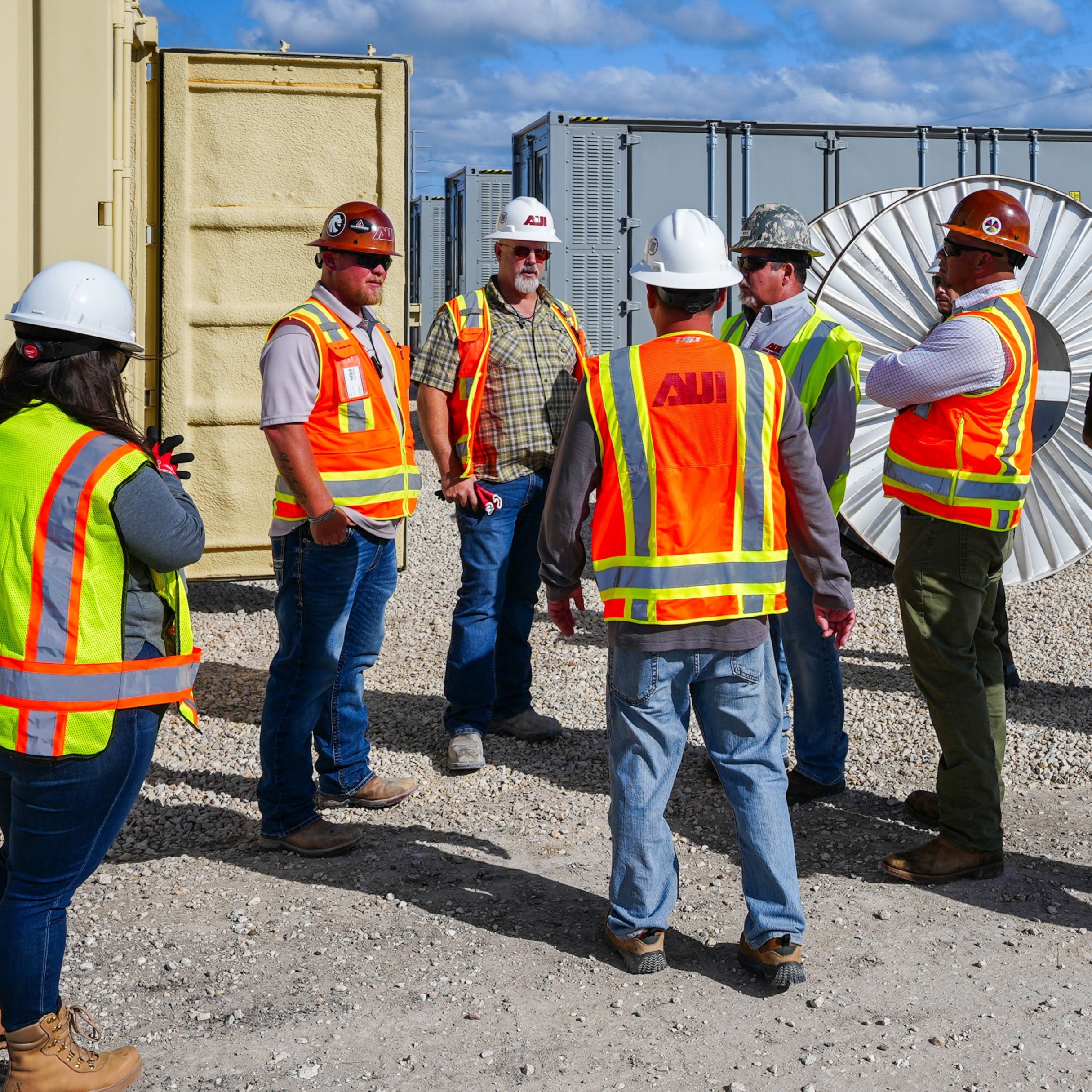 Lydian team members and contractors discussing work at an energy project site.