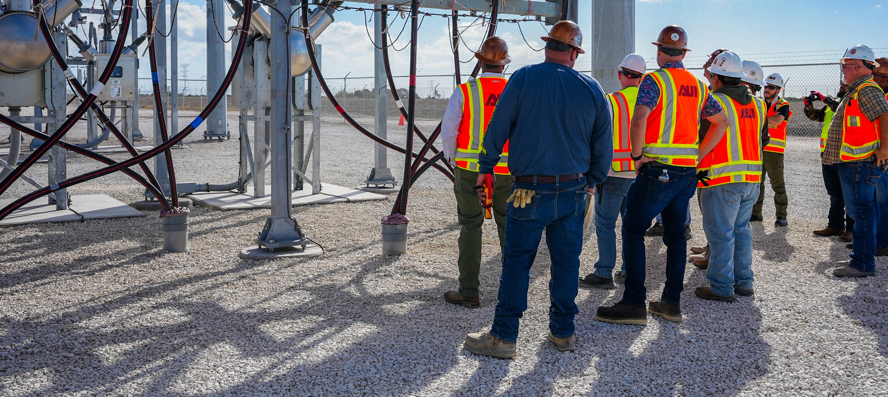 Lydian team members and contractors inspecting electrical infrastructure at an energy project site.