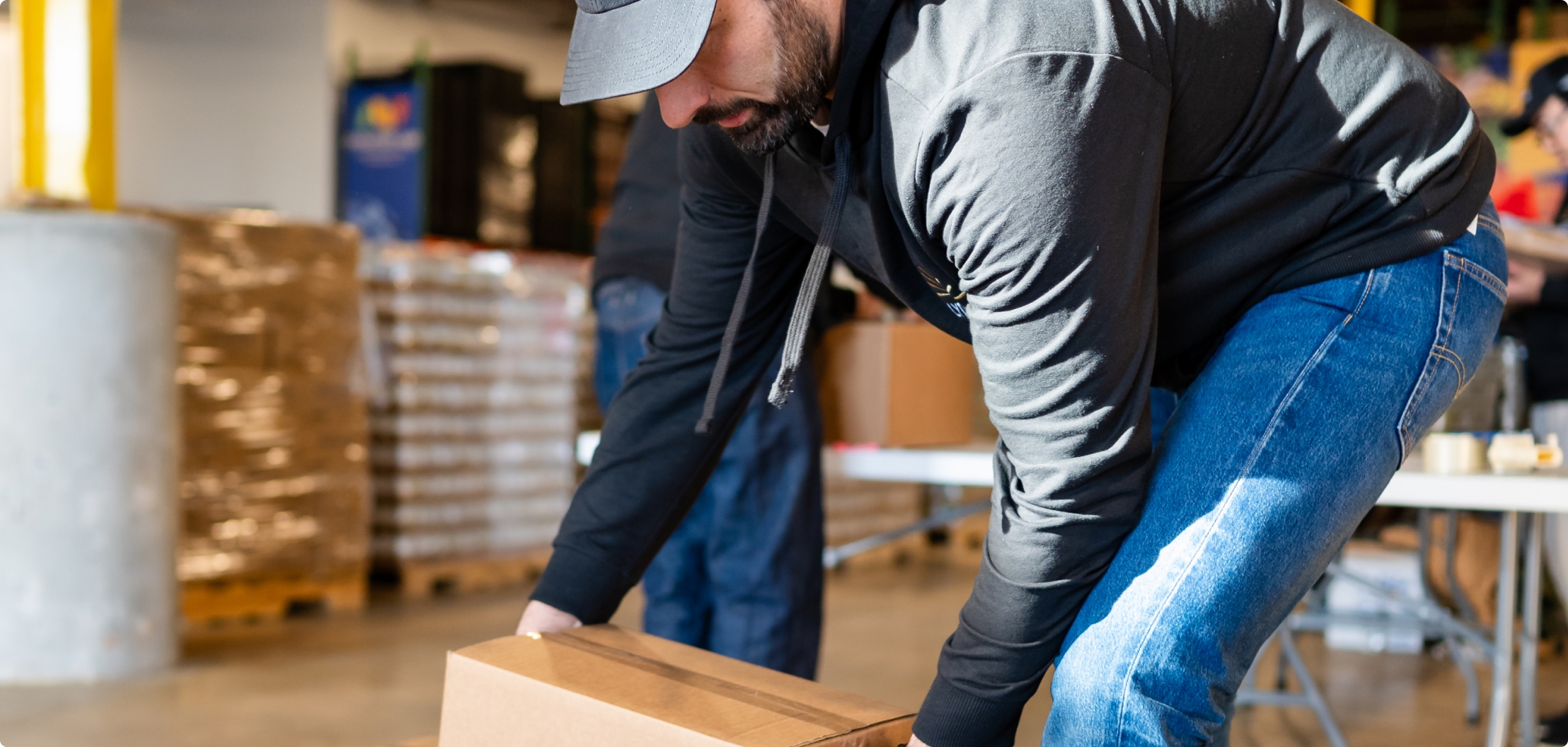 Lydian team member volunteering and packing donated goods at a food bank.