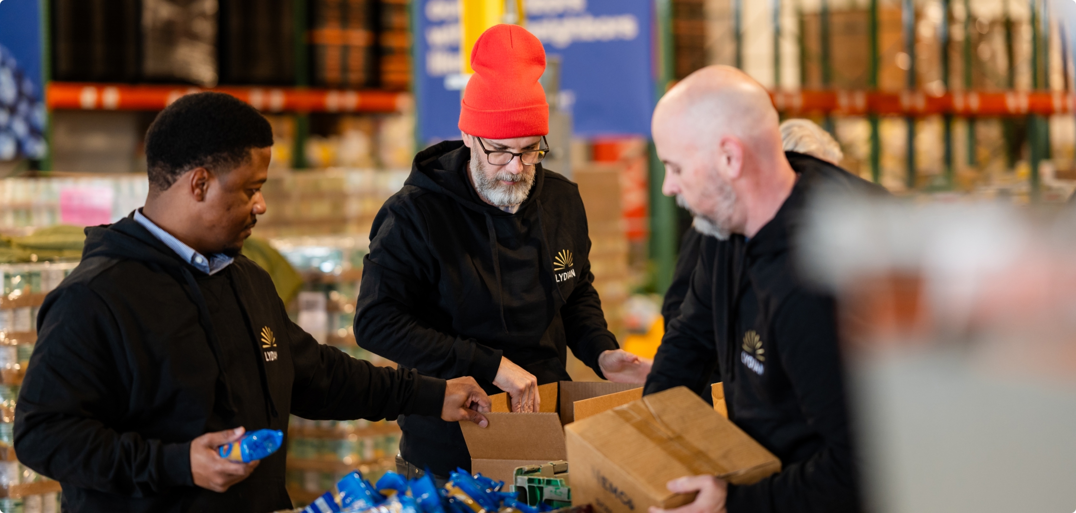 Lydian team members volunteering together and packing food donations.