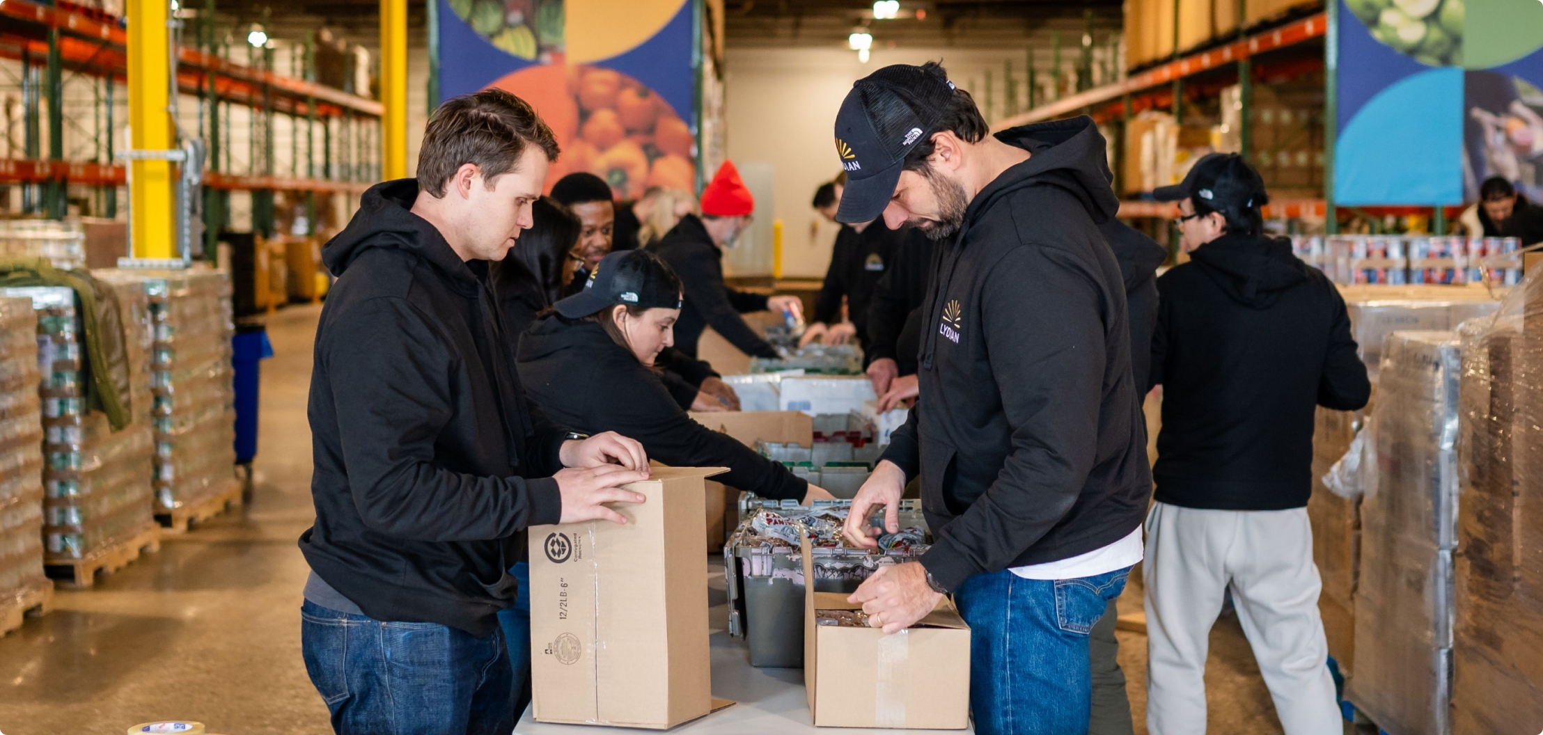 Lydian team members volunteering at a food bank and packing donated goods.